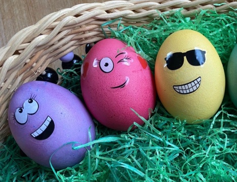 3 lachende gefärbte Eier in einem Osternest